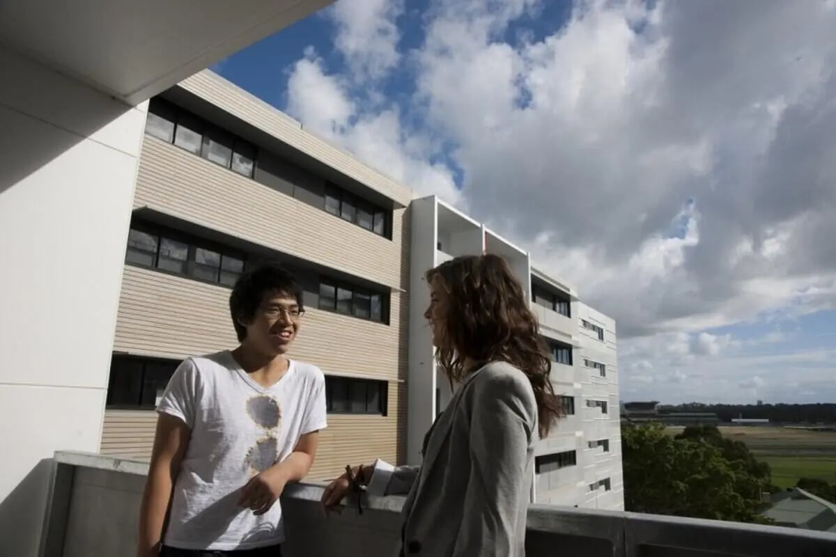 Two students talking on a balcony exterior at UNSW Village in Sydney Student Accommodation