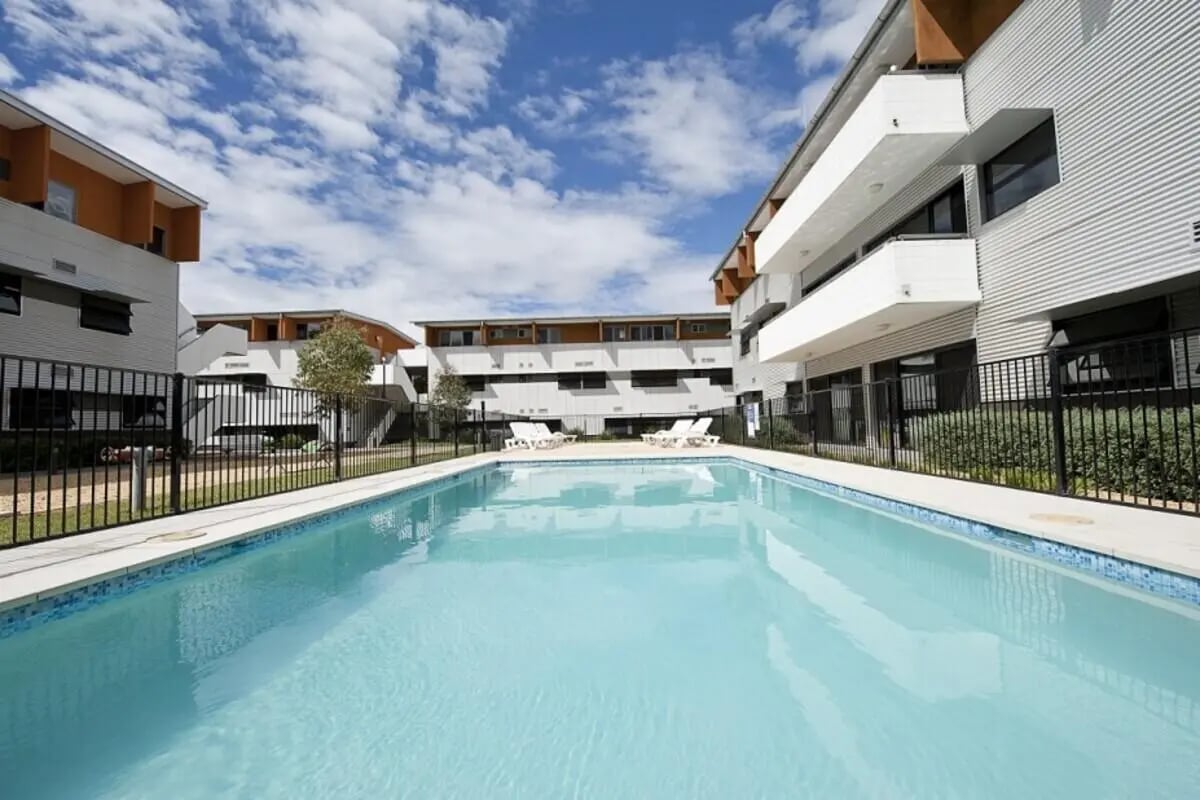 Swimming pool with lounge chairs and buildings exterior at Western Sydney University Village Parramatta Campus in Sydney Student Accommodation