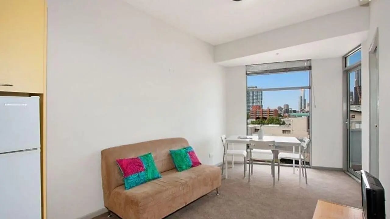 Sofa with pillows dining table living room at Student Living - 570 Swanston in Melbourne Student Accommodation