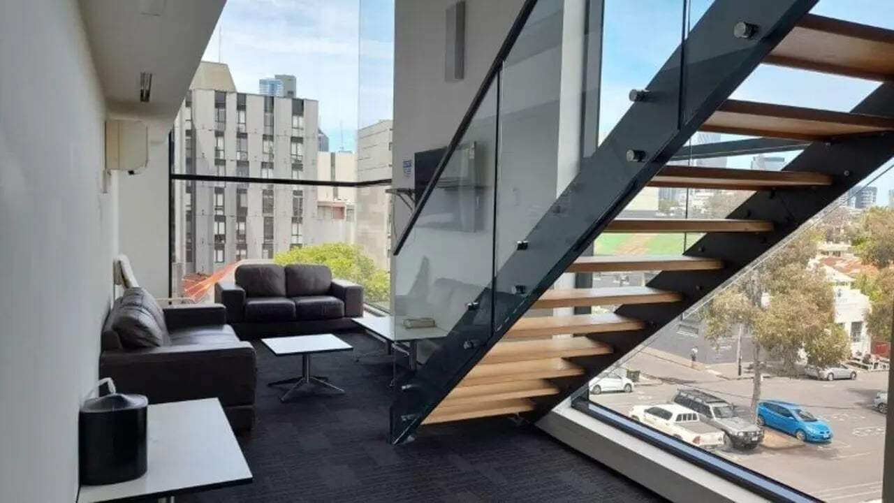 Leather couches coffee table modern stairs living room at Student Living on Villiers in Melbourne Student Accommodation