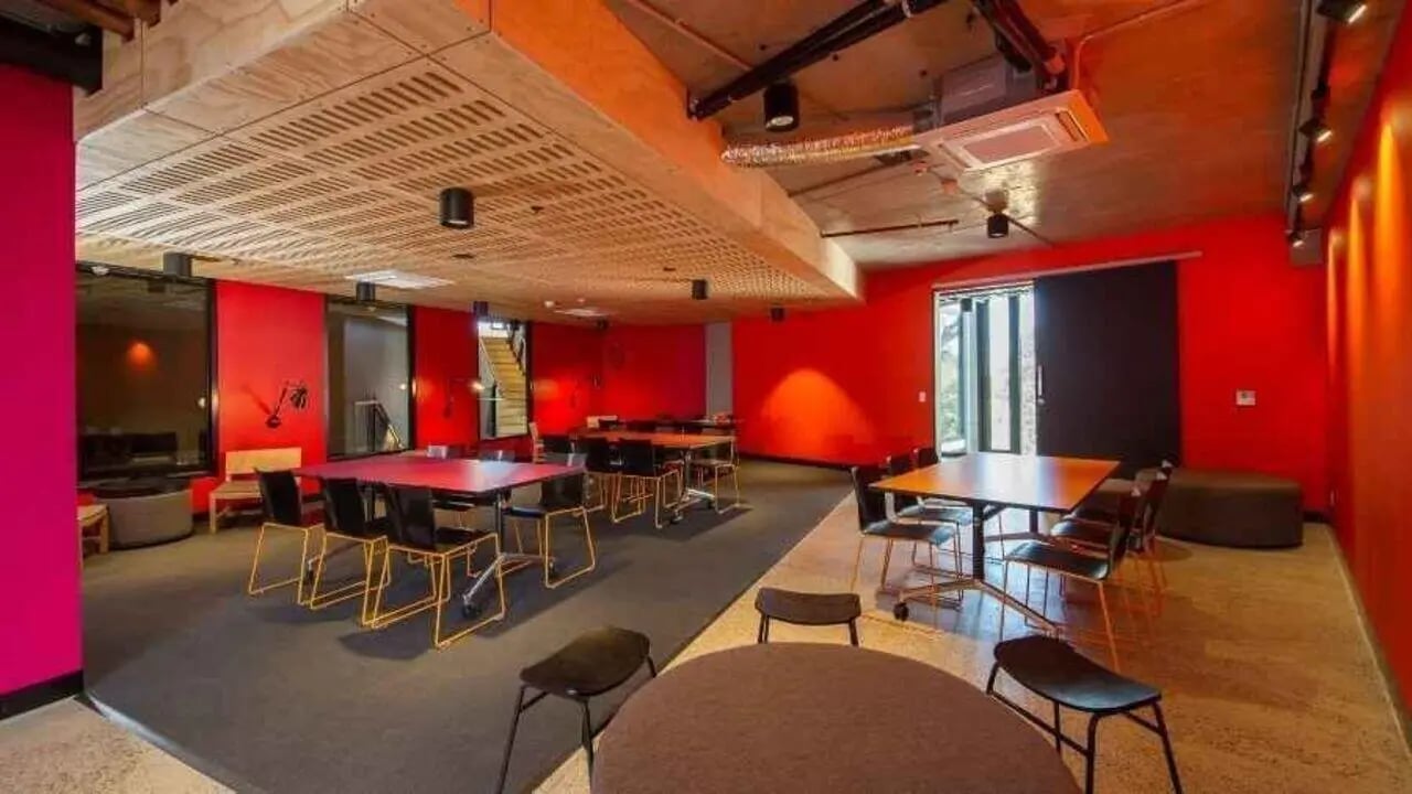 Red walls with tables and chairs communal area at UniLodge @ RMIT Bundoora-Walert House in Melbourne Student Accommodation