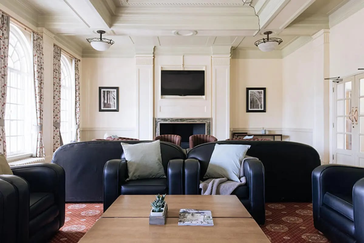 Dark leather sofas and chairs coffee table living room at Oxley Residence in Leeds Student Accommodation
