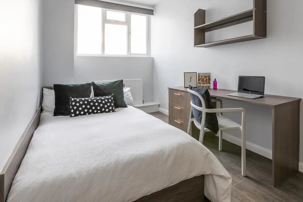 Bed desk chair laptop wall shelf bedroom at Hyde Park in Leeds Student Accommodation