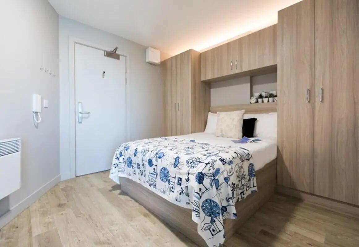 Bed with blue patterned throw and wardrobe bedroom at Caton Court in Lancaster Student Accommodation