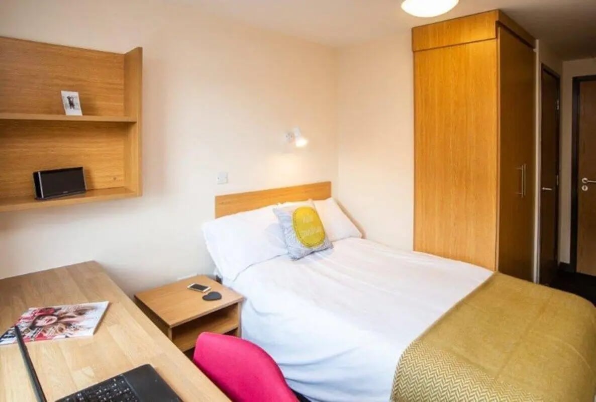 Bed desk shelves wardrobe and door bedroom at Asha House in Loughborough Student Accommodation