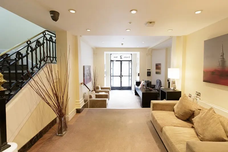 Reception desk couches staircase reception lobby at AXO Oxford Circus in London Student Accommodation
