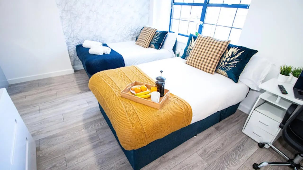 Two beds breakfast tray desk and chair bedroom at Stanley House Nottingham in Nottingham Student Accommodation