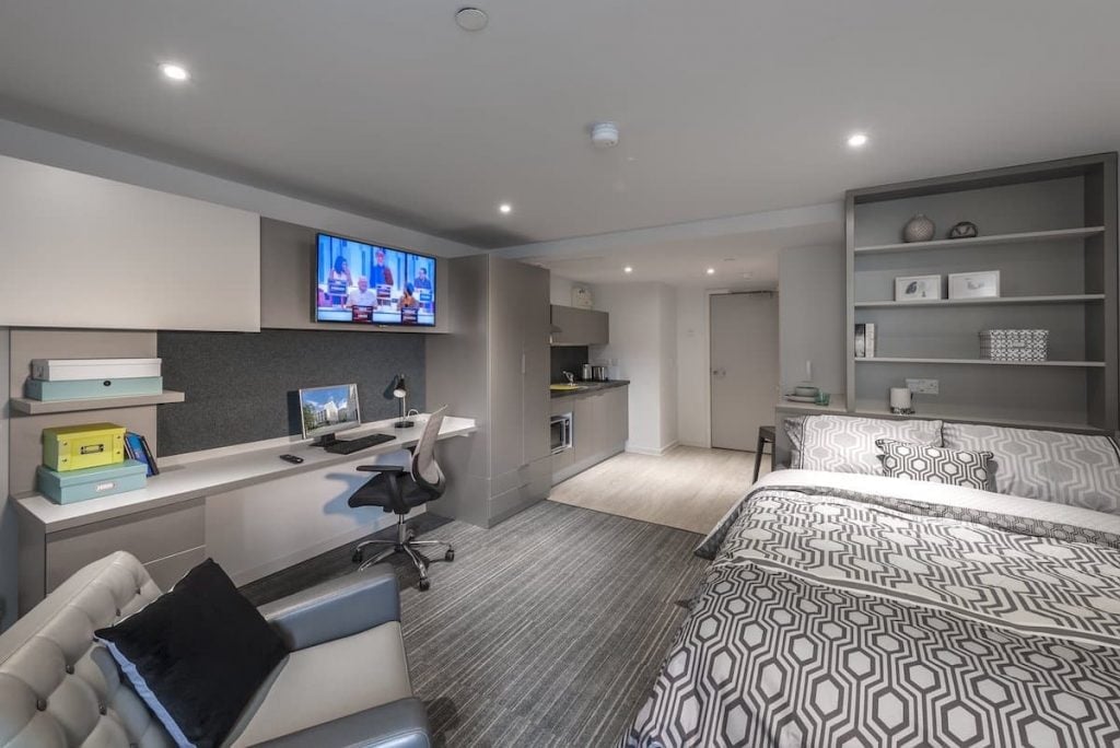 Bed desk kitchen sofa and TV living room at CitySide in Leeds Student Accommodation