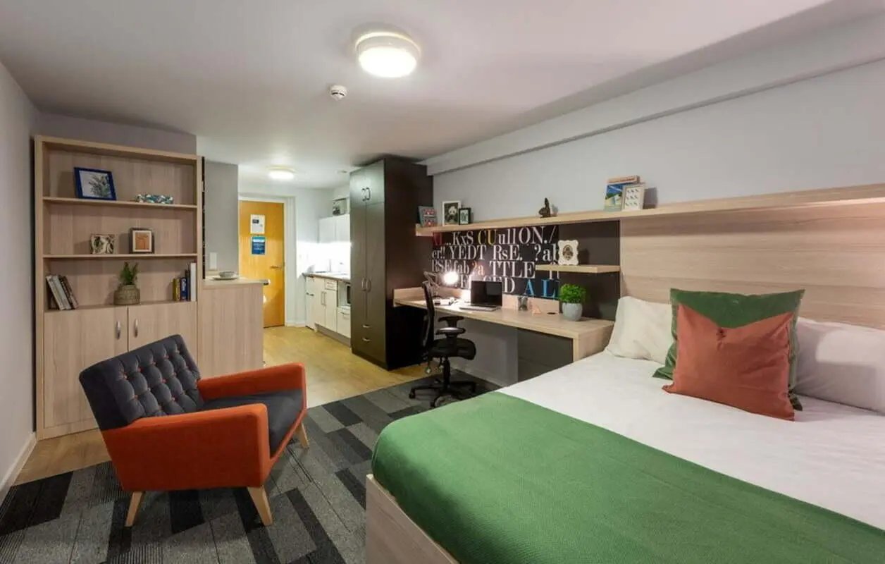 Bed desk chair bookshelf kitchen living area bedroom at The Electra in Liverpool Student Accommodation