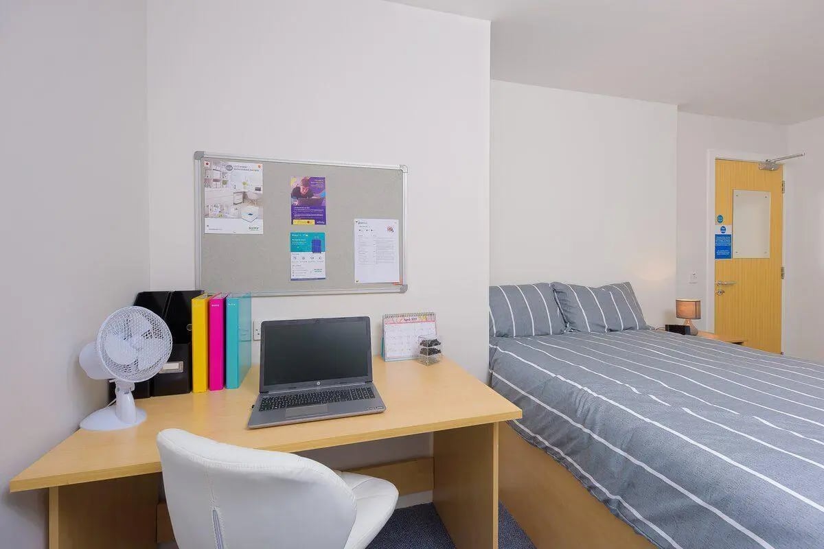 Desk laptop fan binders bed and door bedroom at Keiller Court in Dundee Student Accommodation