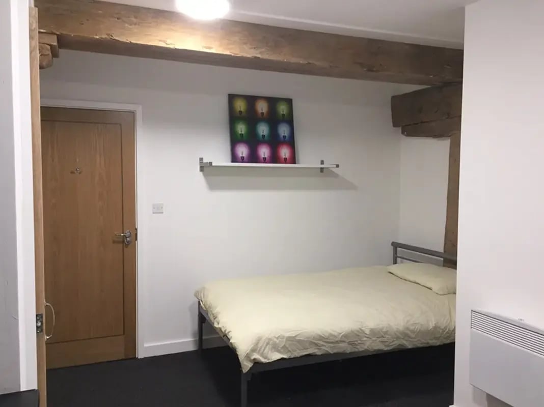 Bed with art and door bedroom at Regent Road in Leicester Student Accommodation