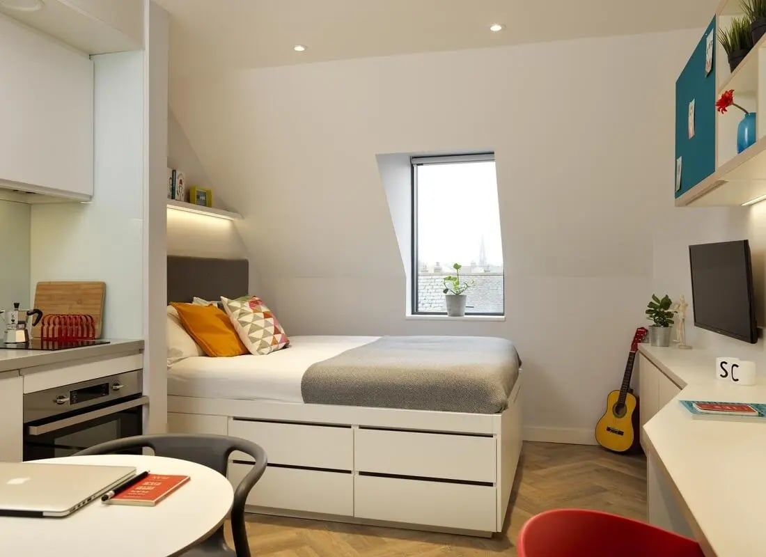Bed desk guitar and kitchenette bedroom at Student Castle Cambridge in Cambridge Student Accommodation