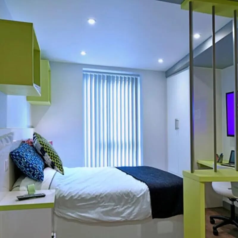 Bed with pillows and desk with laptop bedroom at The Courtyard Block B in Huddersfield Student Accommodation