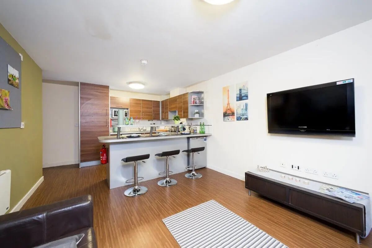 Kitchen island with stools and TV lounge Living room at Aspect 3 Apartments in Sheffield Student Accommodation