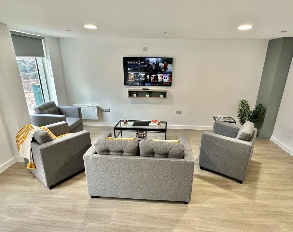 Grey sofas chairs TV coffee table living room at Albany Student Village in Coventry Student Accommodation
