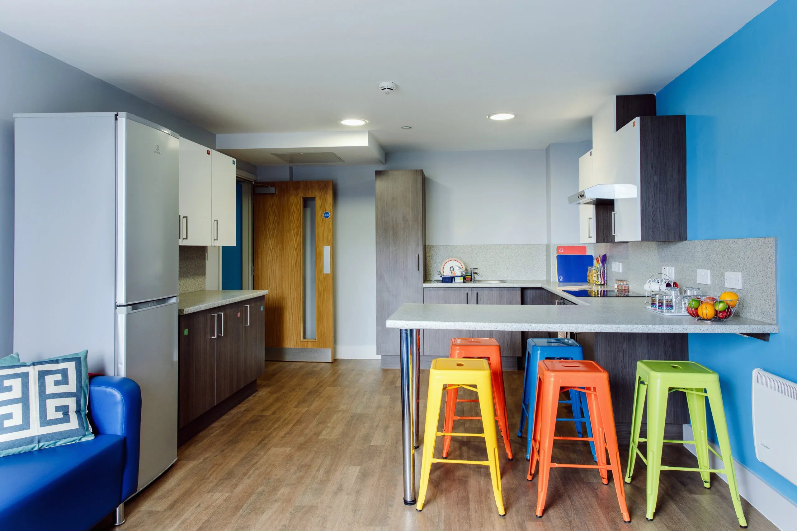 Modern kitchen with colorful stools and appliances kitchen at Kaplan Living Bournemouth in Bournemouth Student Accommodation