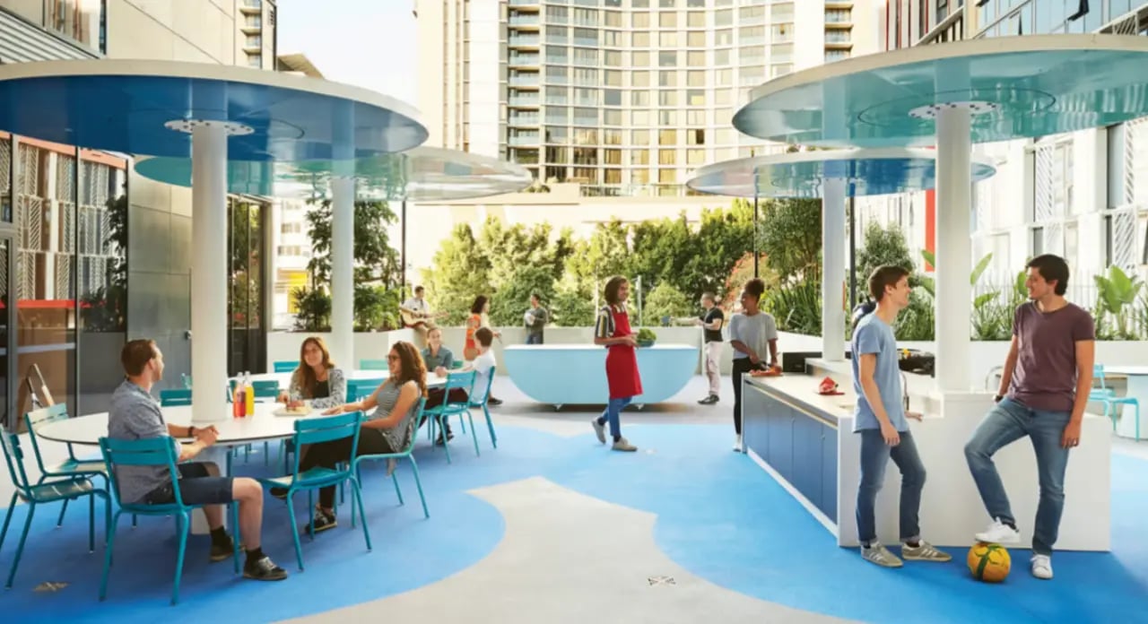 People dining at table and cooking area living room at Scape South Bank in Brisbane Student Accommodation