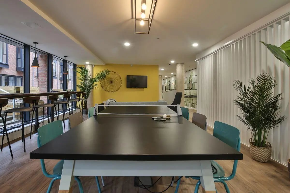 Ping pong table with chairs lounge and bar area at Ocean View in Falmouth Student Accommodation