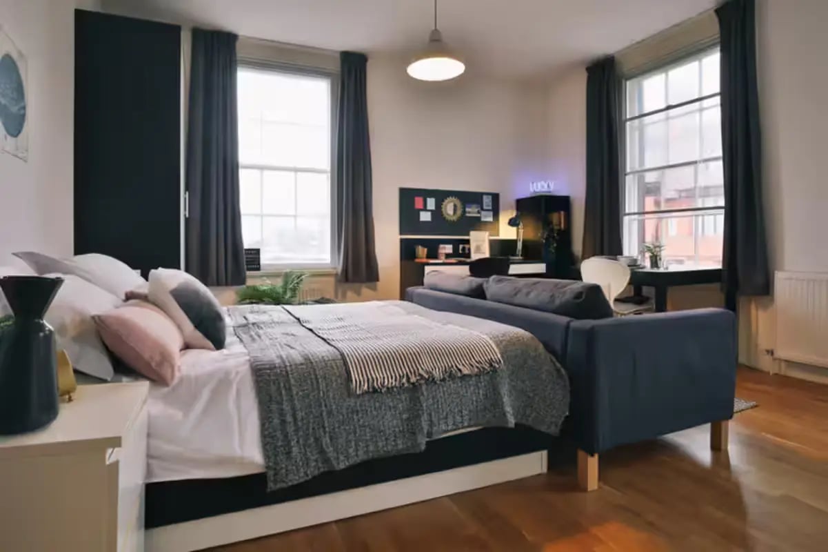 Bed couch desk and plants studio apartment at Art School Lofts in Liverpool Student Accommodation