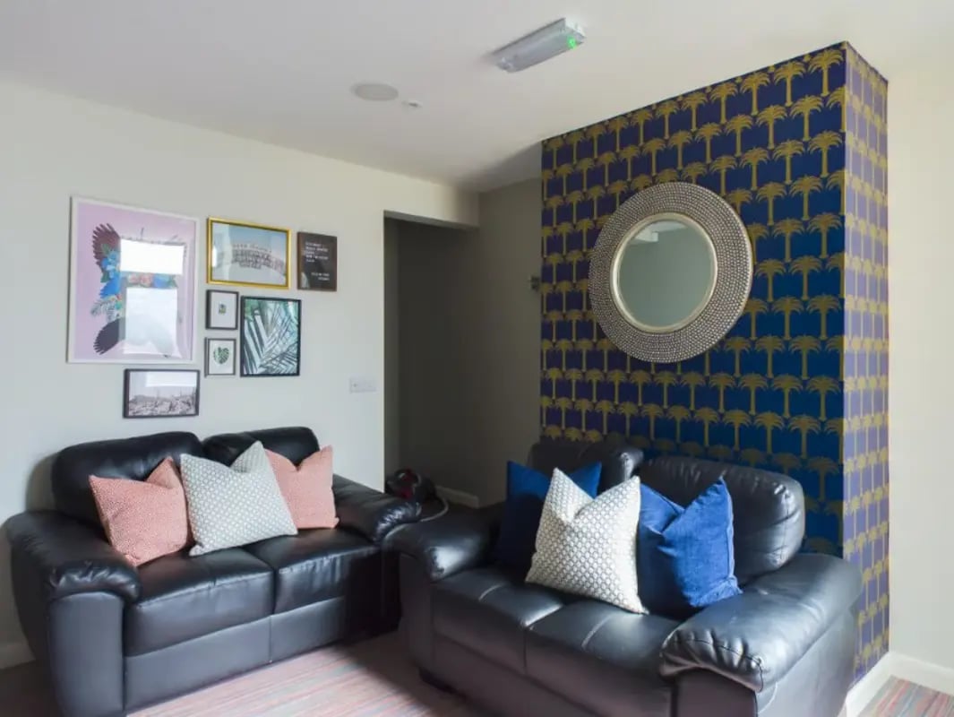 Two black sofas framed art patterned wall living room at 26 Beresford Street in Stoke-On-Trent Student Accommodation