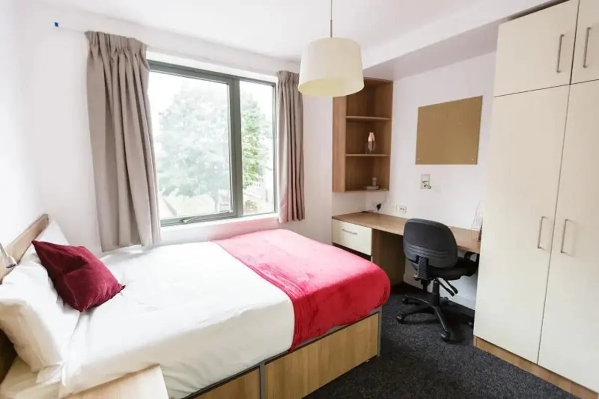 Bed desk chair wardrobe shelving unit bedroom at AXO Camden in London Student Accommodation