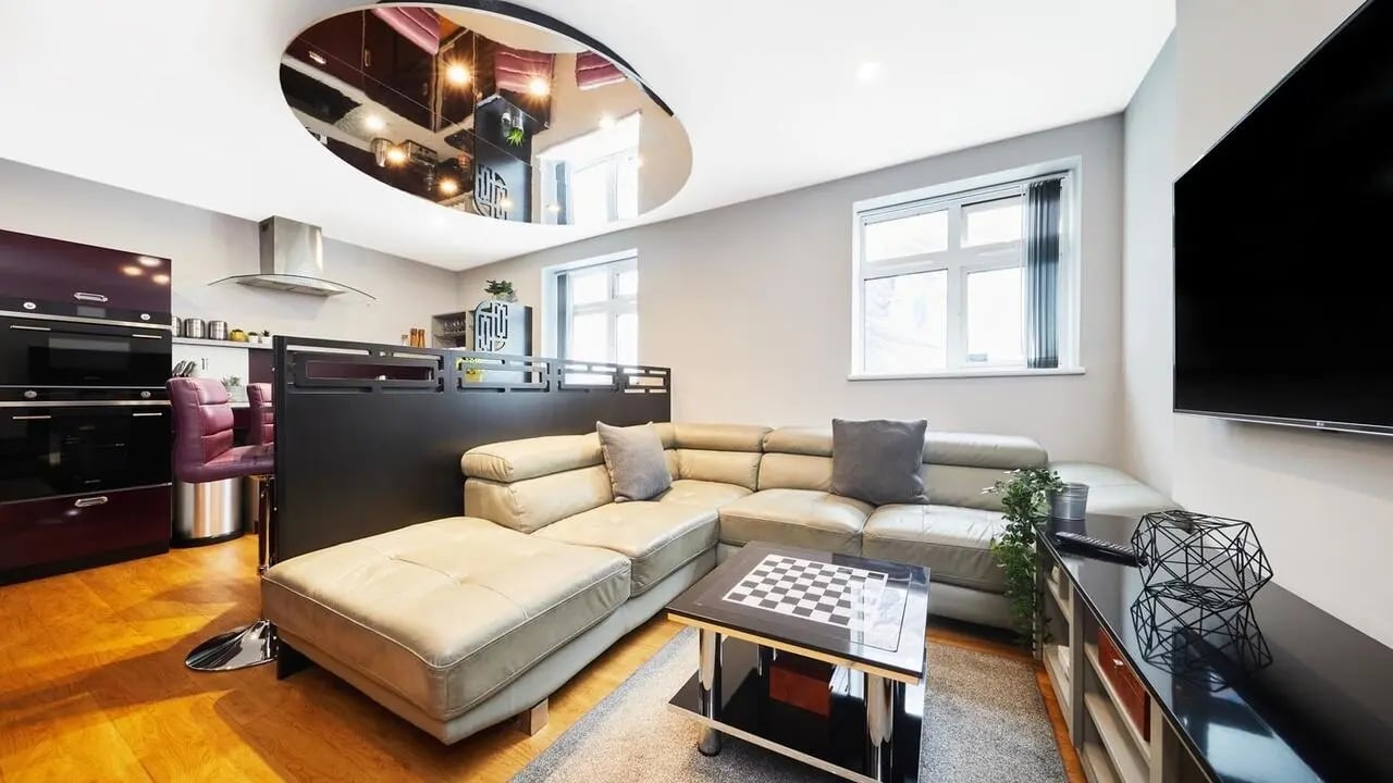 Leather sectional sofa chessboard coffee table kitchen living room at Pillar Box in Coventry Student Accommodation