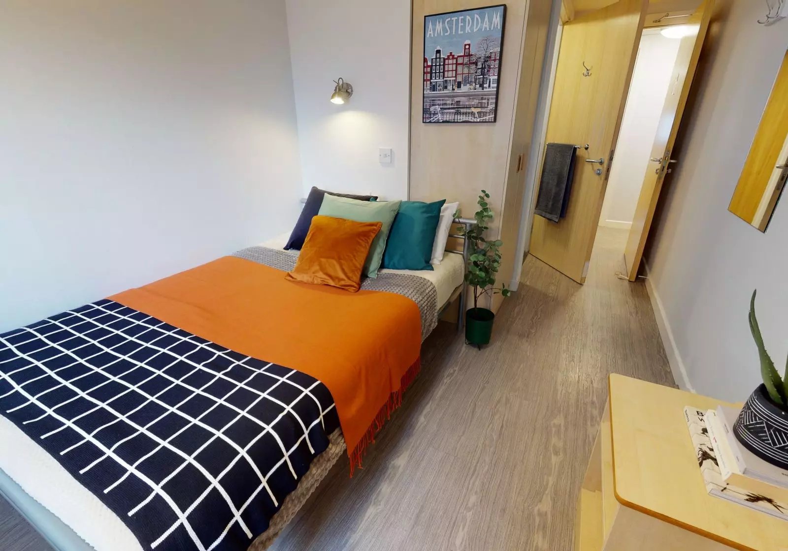 Bed with orange throw and pillows bedroom at iQ Grosvenor House in Leicester Student Accommodation
