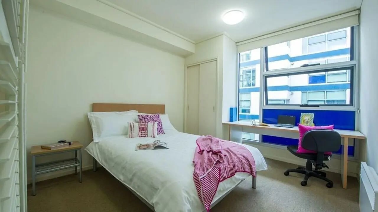 Bed desk chair and window bedroom at Student Living - 800 Swanston in Melbourne Student Accommodation