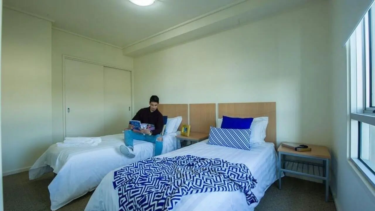Two beds with blue patterned blanket and a student bedroom at Student Living - 550 Lygon in Melbourne Student Accommodation
