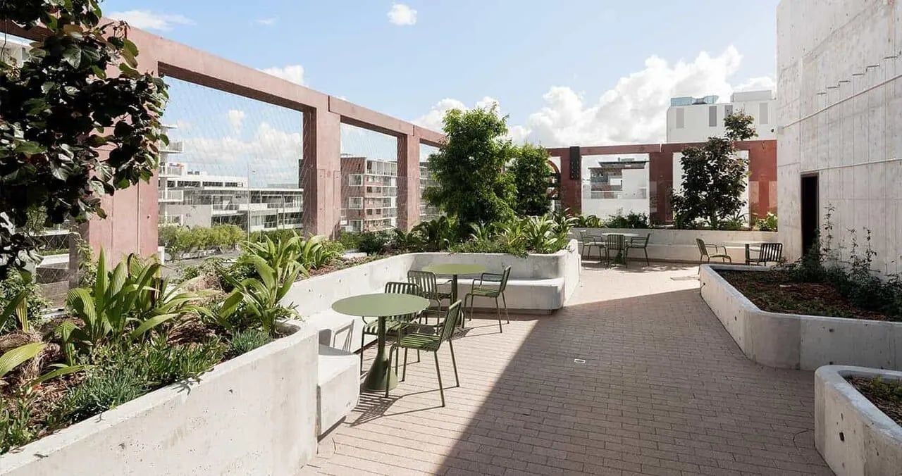 Tables chairs and planter beds on rooftop patio exterior at Iglu Mascot in Sydney Student Accommodation