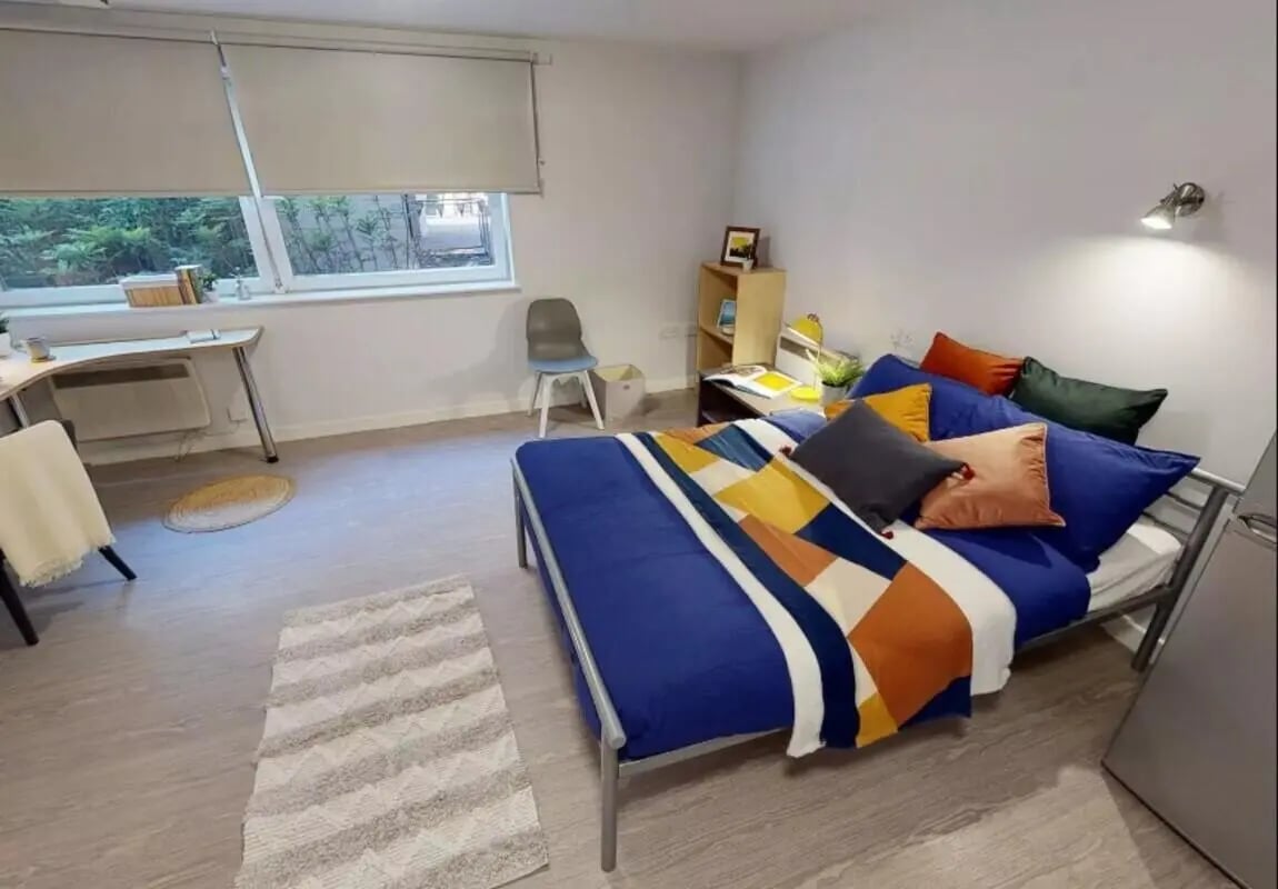 Bed desk chair rug and window bedroom at iQ Marsden House in Leeds Student Accommodation