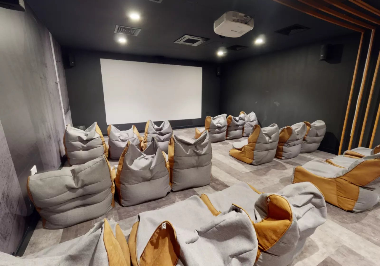 Beanbag chairs surround a large projection screen media room at iQ Hammersmith in London Student Accommodation