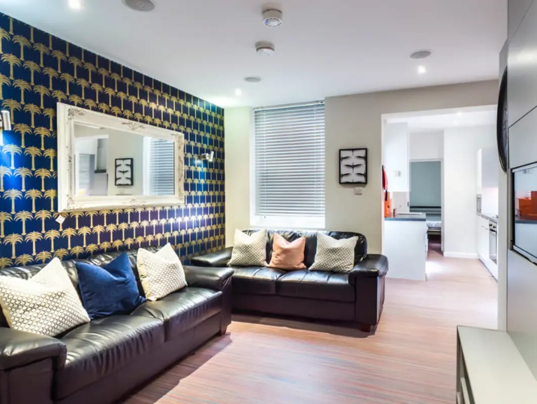 Leather sofas and patterned wallpaper living room at 41 Seaford Street in Stoke-On-Trent Student Accommodation