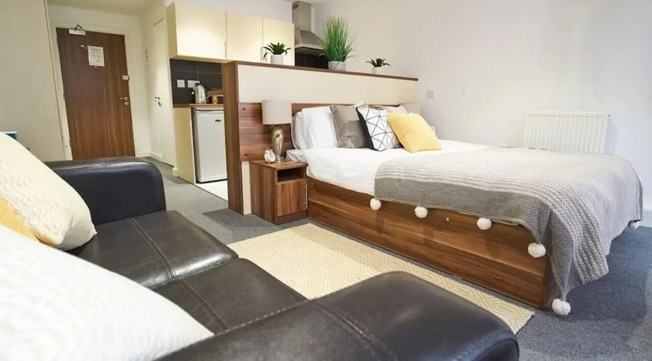 Bed couch kitchen area with mini fridge and door at Windsor Court in Liverpool Student Accommodation