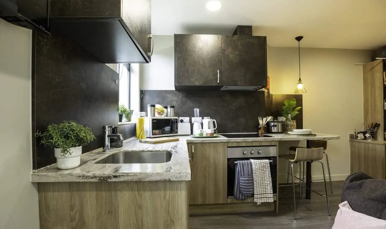 Modern student kitchen with microwave kettle and stools kitchen at St Peter's Hall in Bournemouth Student Accommodation