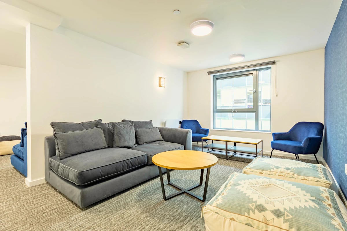 Gray couch blue chairs coffee tables living room at Justice Mill Studios in Aberdeen Student Accommodation