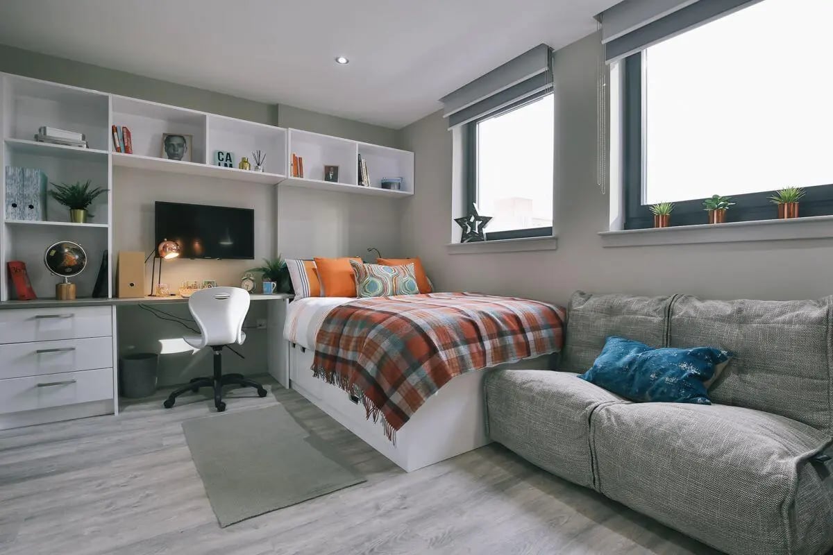 Bed desk chair shelves couch bedroom at George Street Apartments in Glasgow Student Accommodation