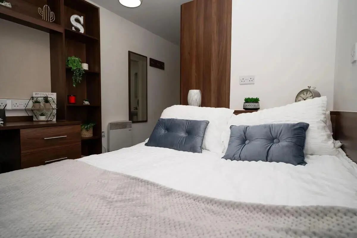 Bed with grey cushions and shelving bedroom at Walker Street in Preston Student Accommodation