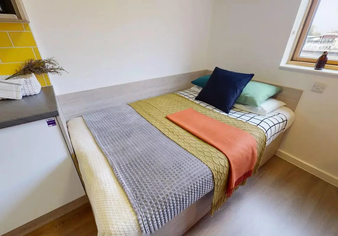 Bed with colorful blankets and pillows Bedroom at iQ Kingston in Kingston Upon Thames Student Accommodation