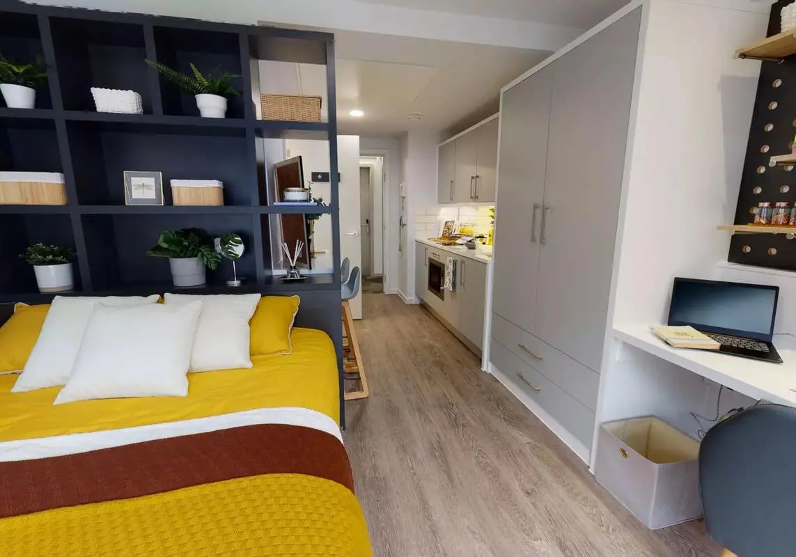 Bed with shelving kitchen and desk studio apartment at iQ Bloomsbury in London Student Accommodation