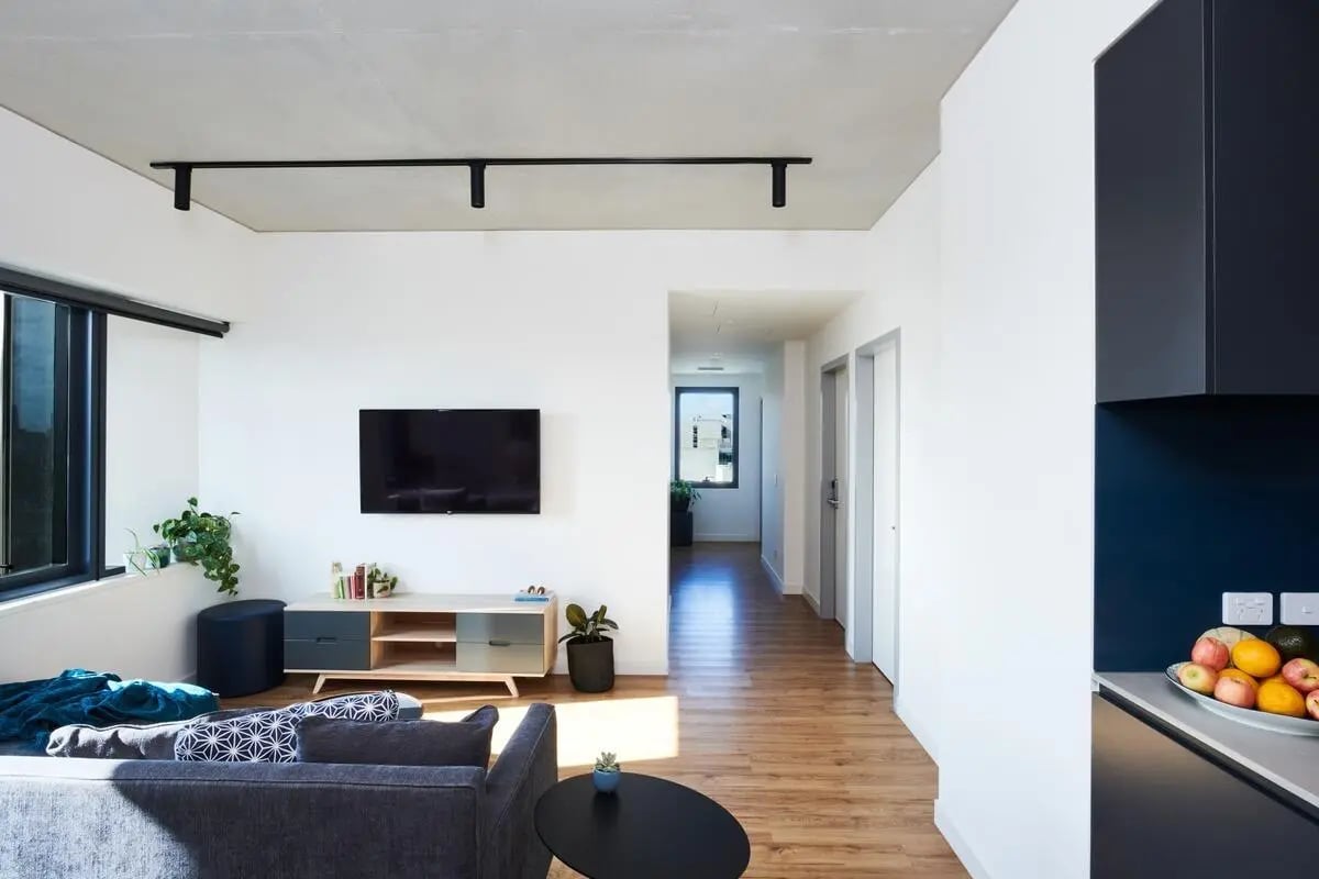 Sofa TV media unit hallway kitchen living room at Scape Uni Square in Melbourne Student Accommodation