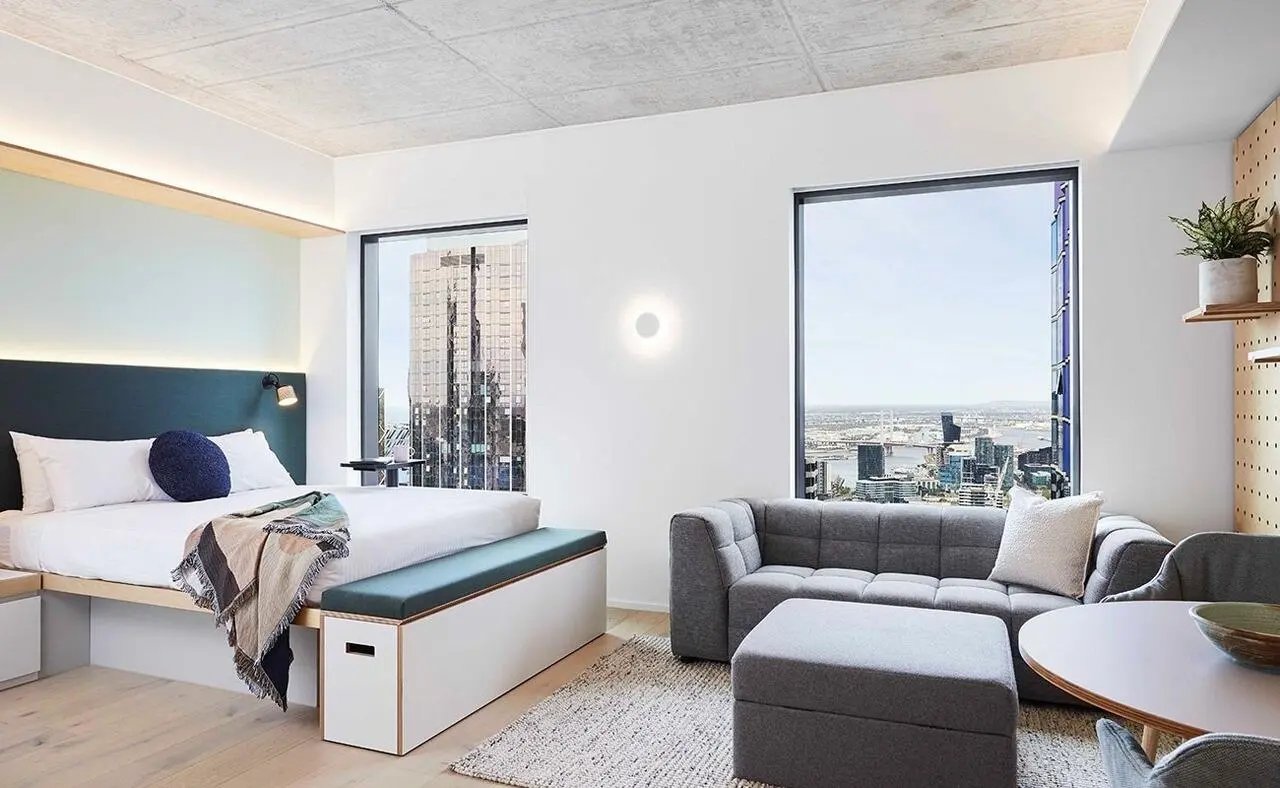 Bed sofa table and city view living room at Scape Franklin in Melbourne Student Accommodation