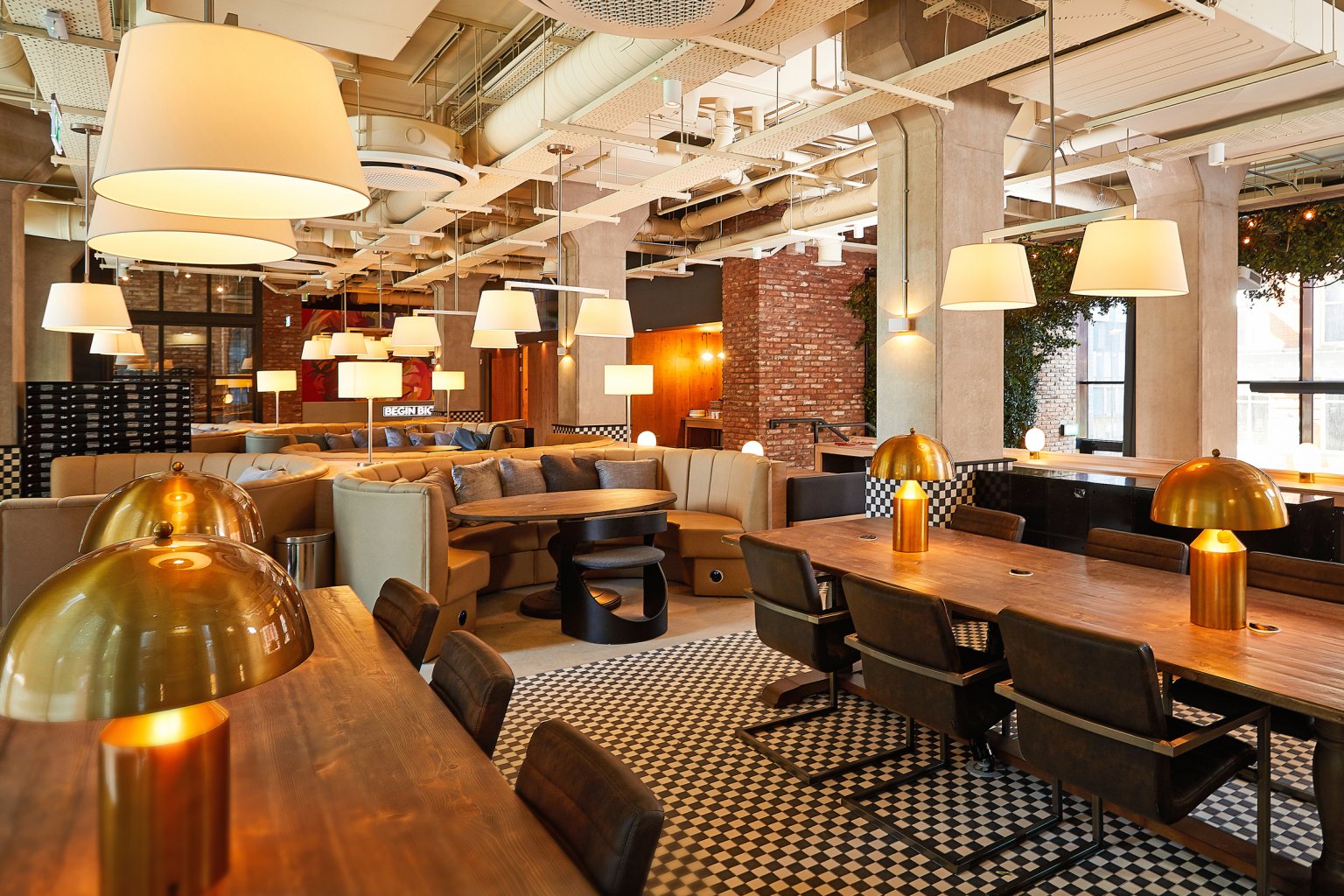 Modern lounge with communal tables and seating area at Vita Student Manchester Circle Square in Manchester Student Accommodation
