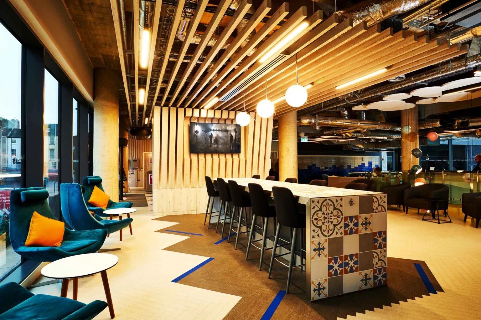 Modern common area with bar seating and lounge chairs at Vita Student Newcastle Strawberry Place in Newcastle Upon Tyne Student Accommodation