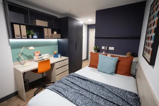 Desk with lamp chair and bed with pillows Bedroom at Tribeka in Leeds Student Accommodation