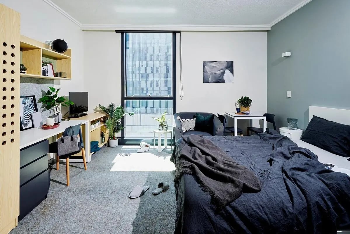 Bed desk chair sofa and dining table bedroom at Scape Darling Square in Sydney Student Accommodation