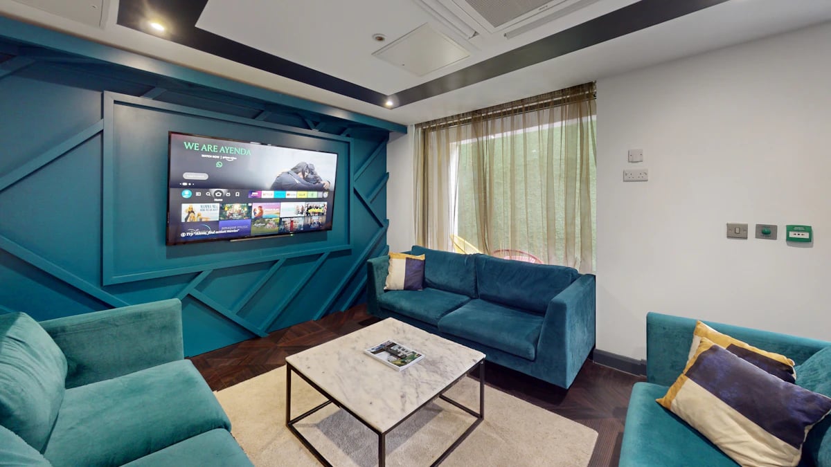 Teal sofas television and coffee table living room at The Residence in Coventry Student Accommodation