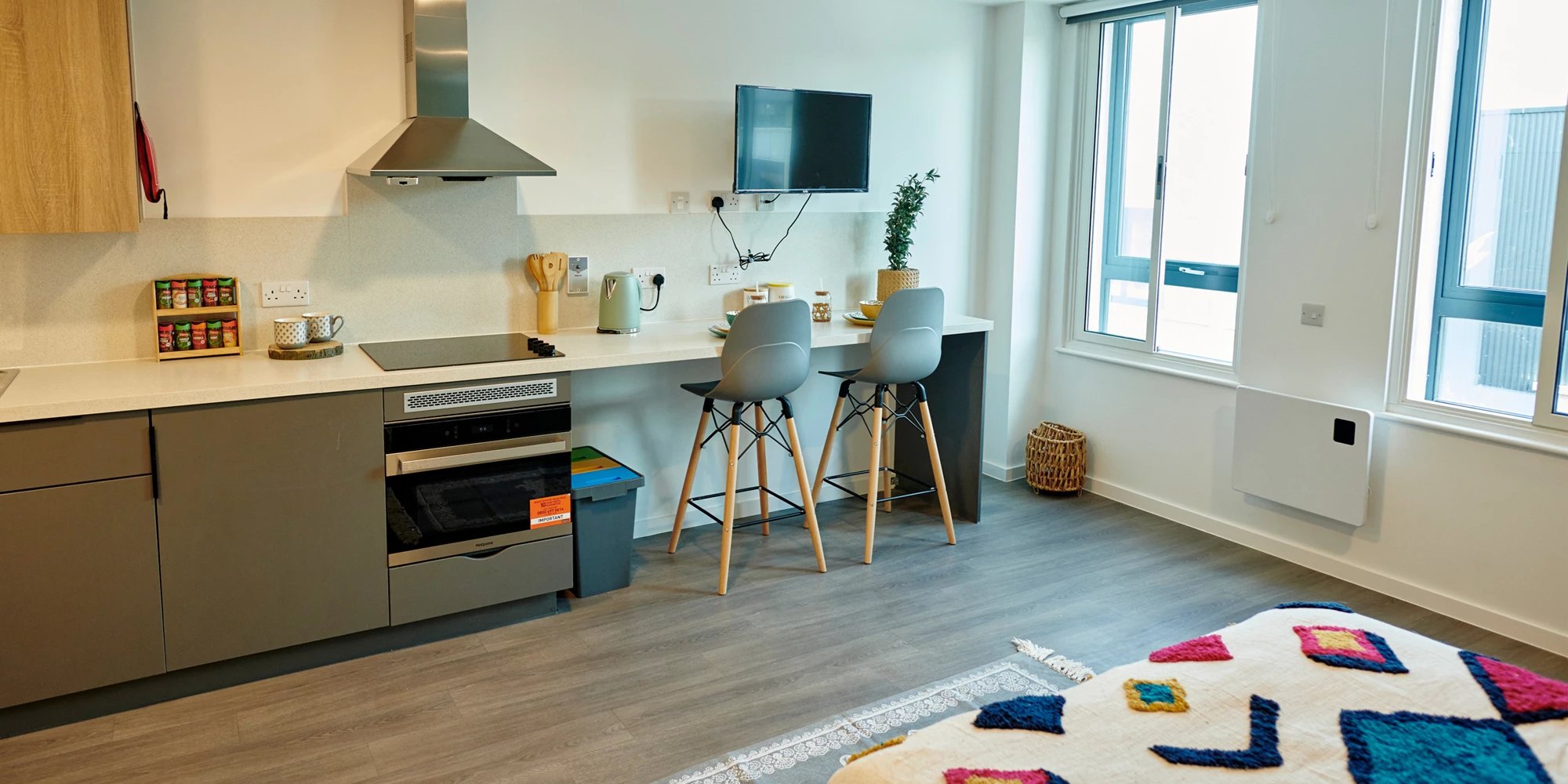 Kitchenette with bar stools and bed Image Type at Canvas Bristol in Bristol Student Accommodation