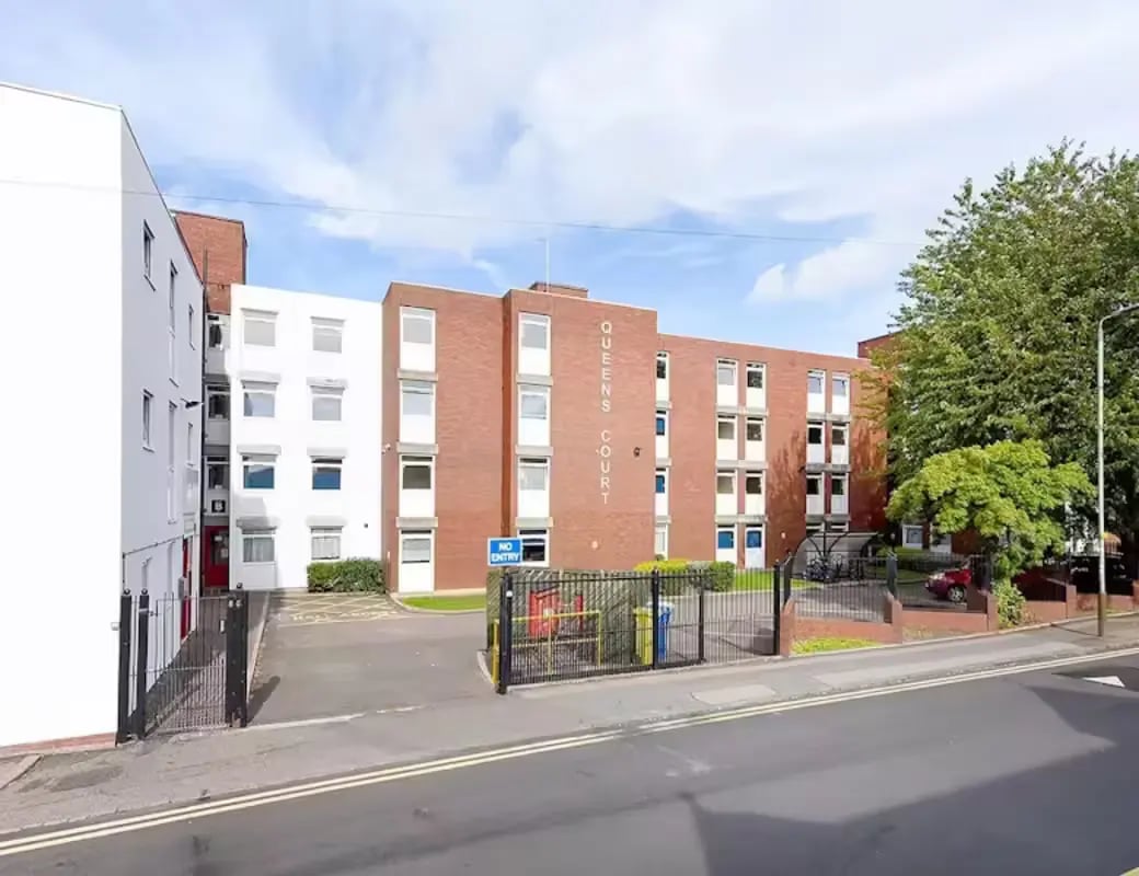 Queens Court building with cars parked exterior at Queens Court Leicester in Leicester Student Accommodation