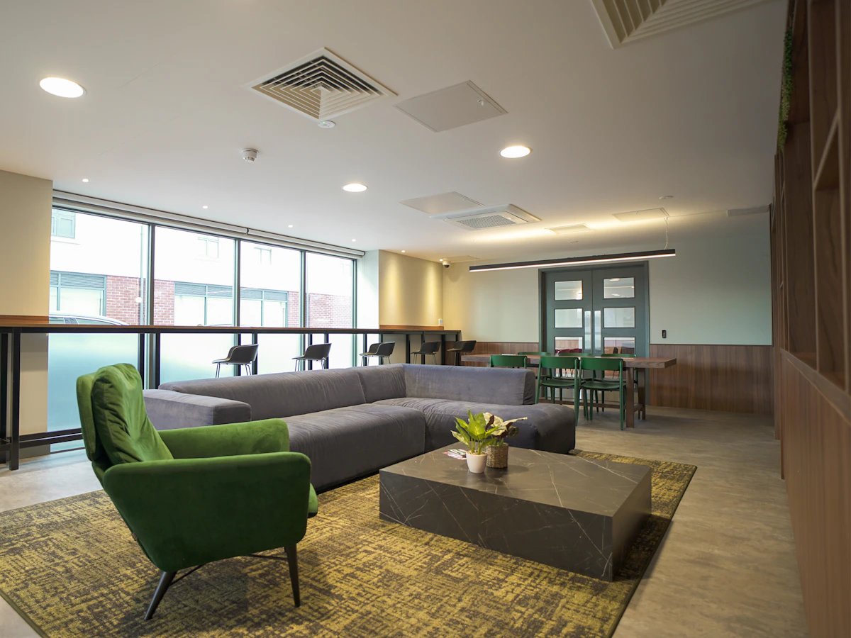 Grey sectional sofa green armchair marble coffee table living room at Straits Garden in Egham Student Accommodation